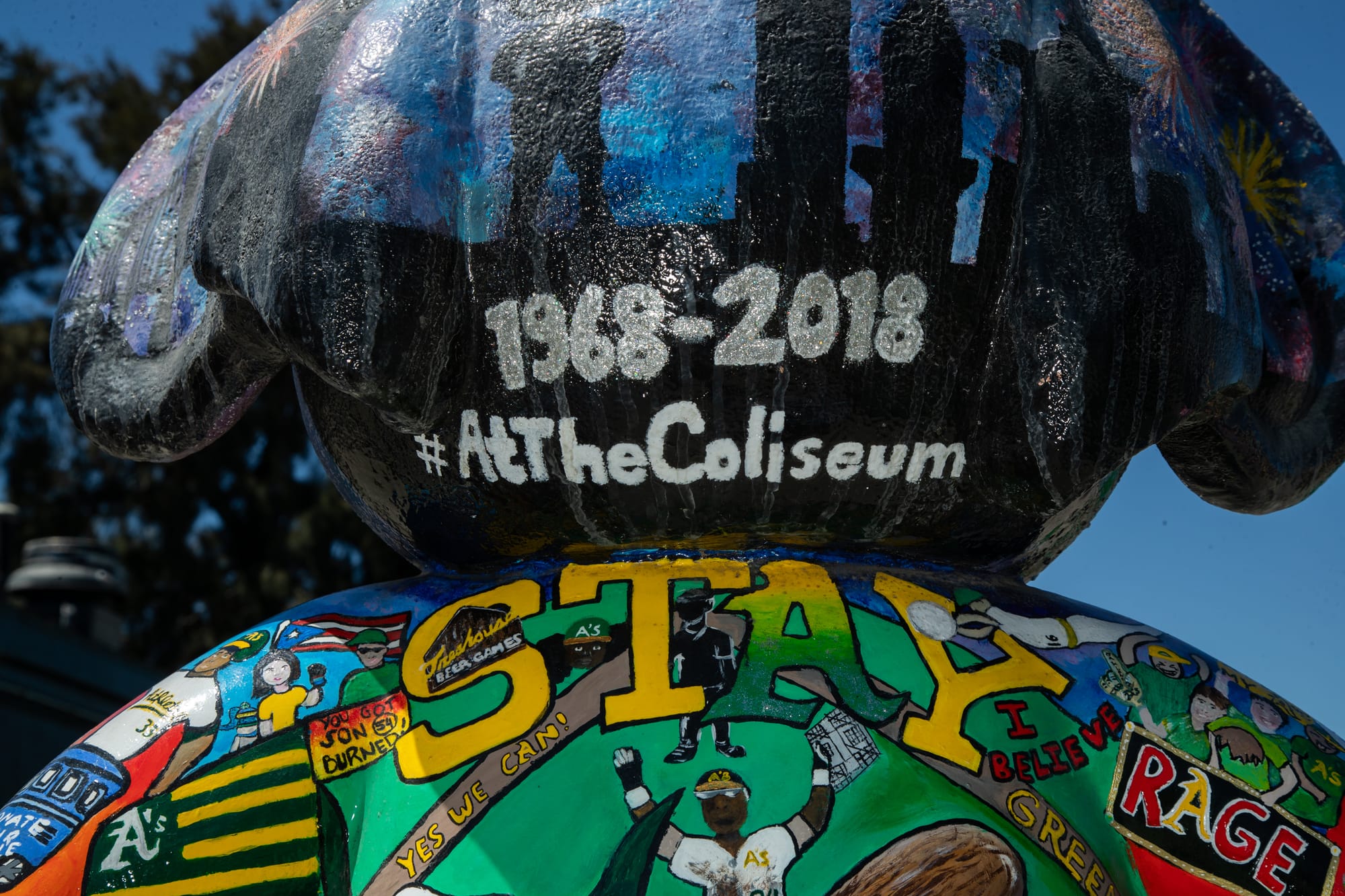 View from behind a statue of an anthropomorphic elephant. Text painted on the head says "1968-2018 #AtTheColiseum."