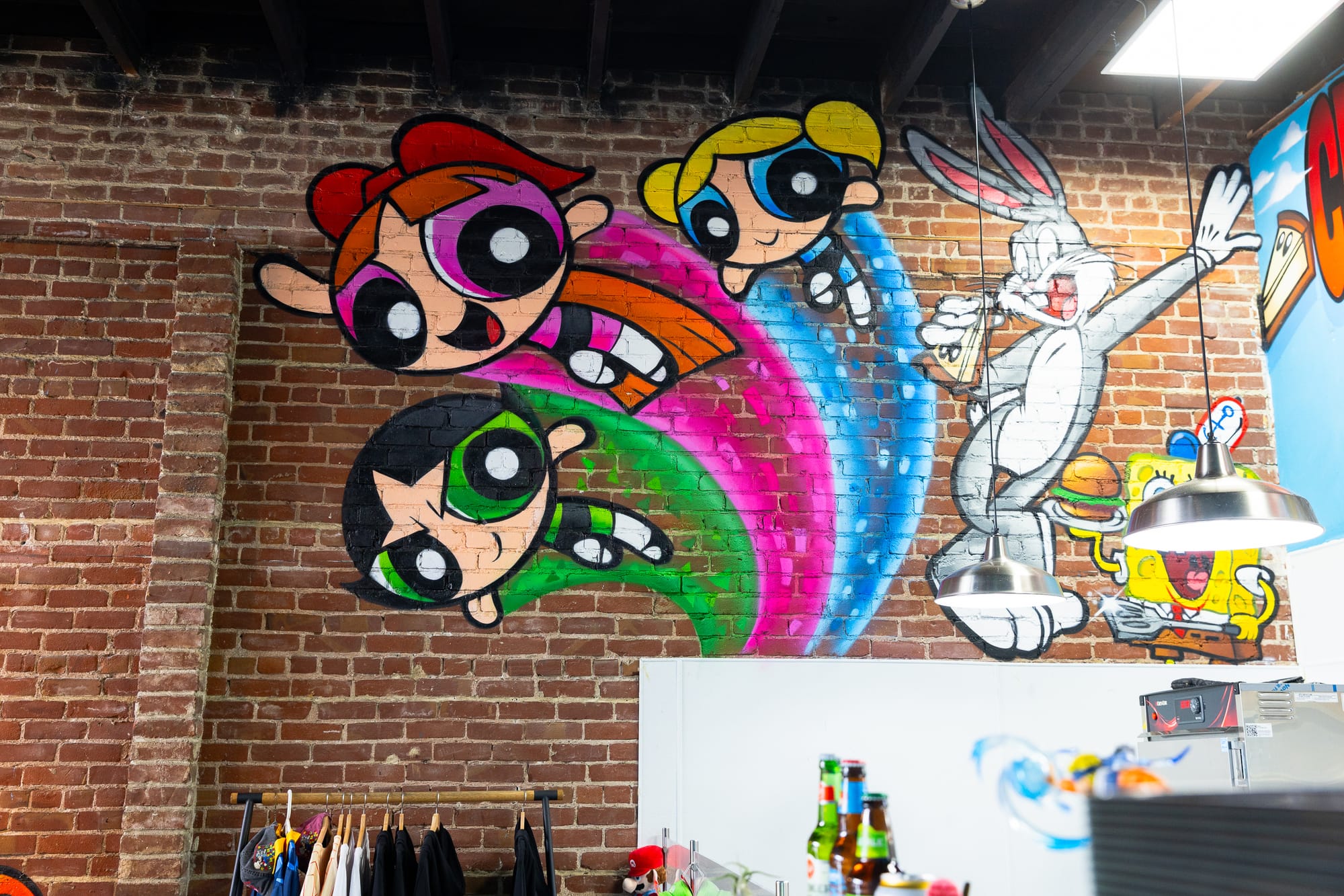 Mural on a brick wall displaying Powerpuff Girls, Bugs Bunny, and Spongebob.