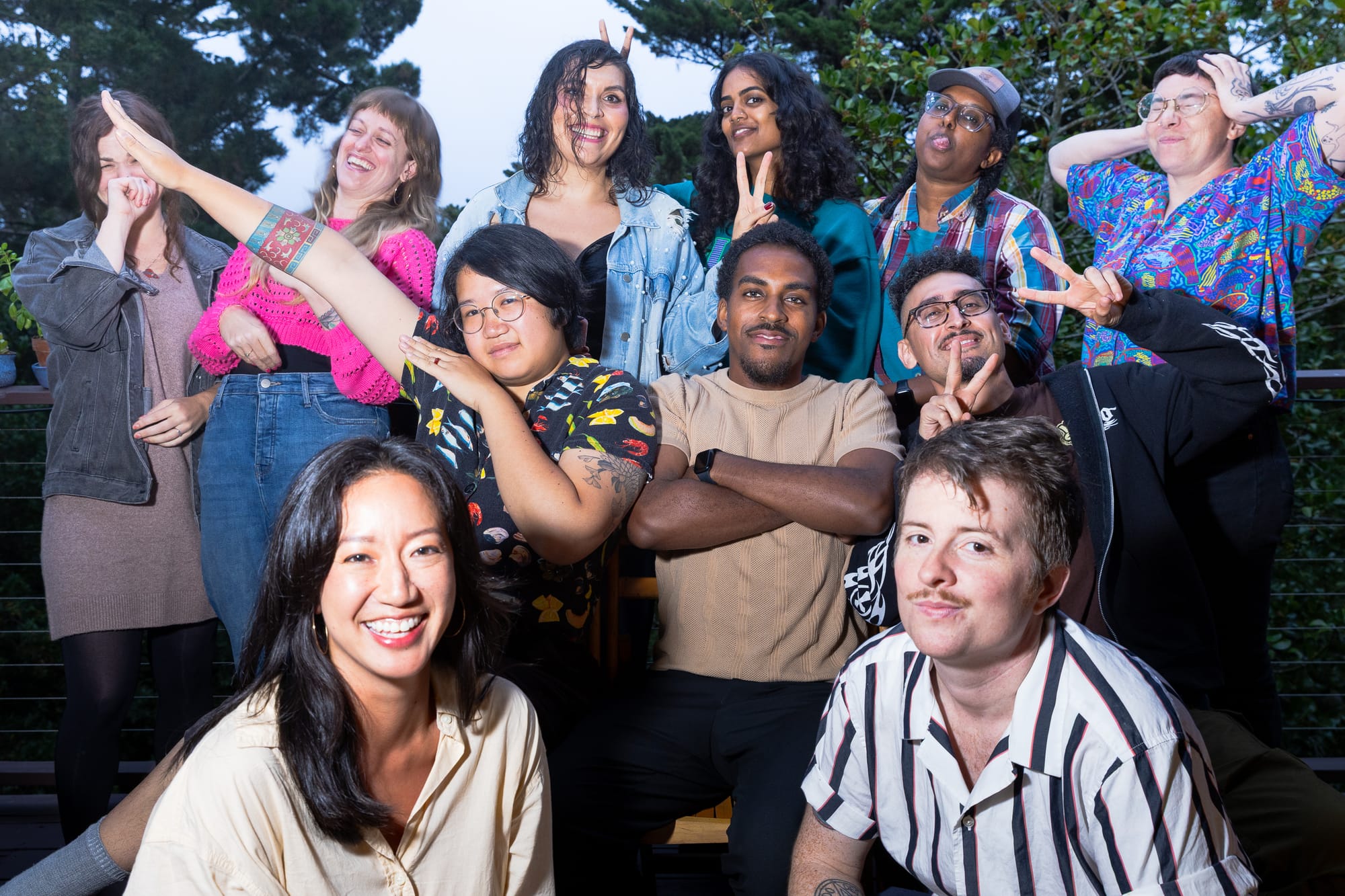 11 people pose in a silly way on a balcony.