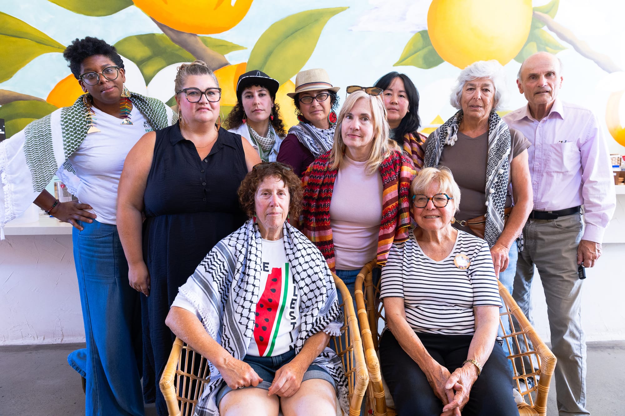 ten people of mixed genders and races pose for a group portrait in a coffee shop