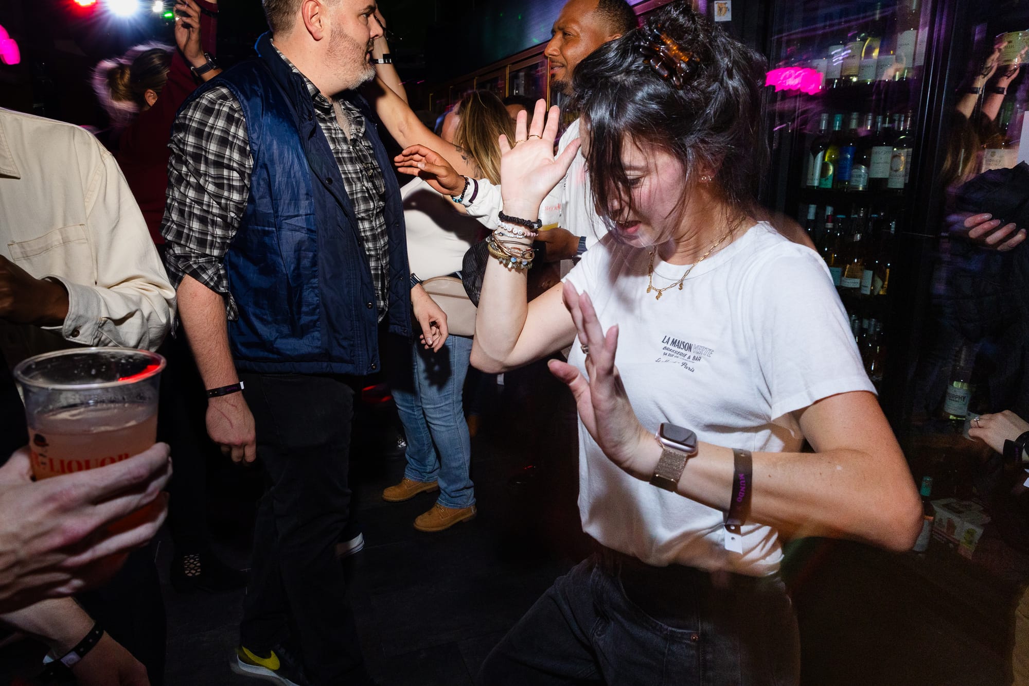A person dances low to the ground in a crowded dance floor.  