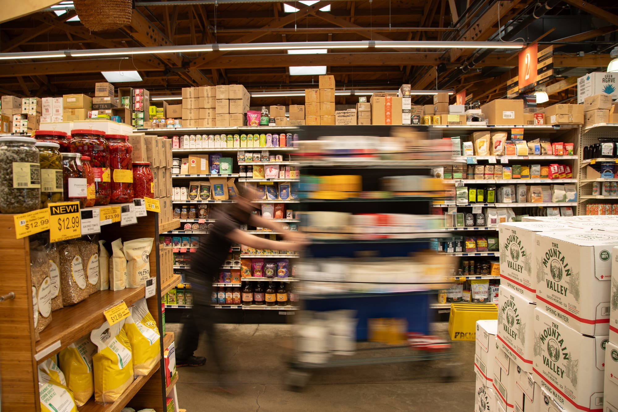 a blurry image of an emplooyee pushing a display in a grocery store