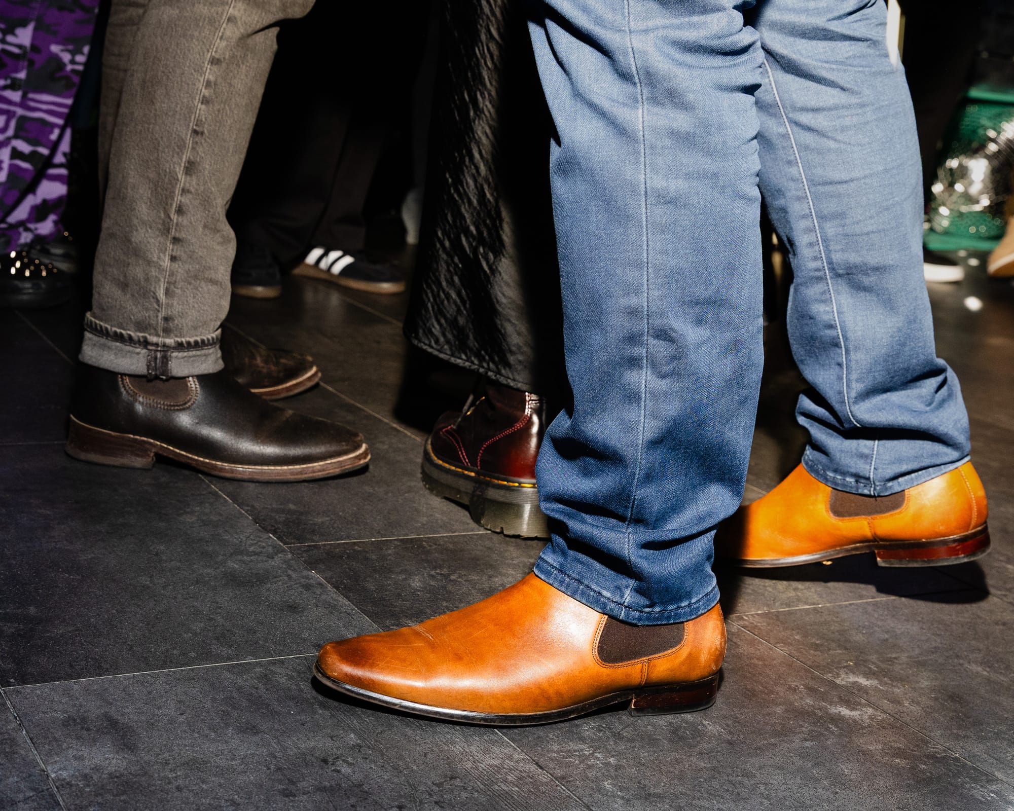 A close up of several different types of party goers shoes 