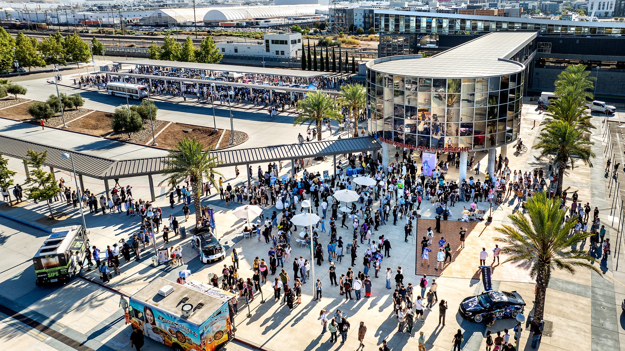 Aerial view of a crowd assembled at a train station.