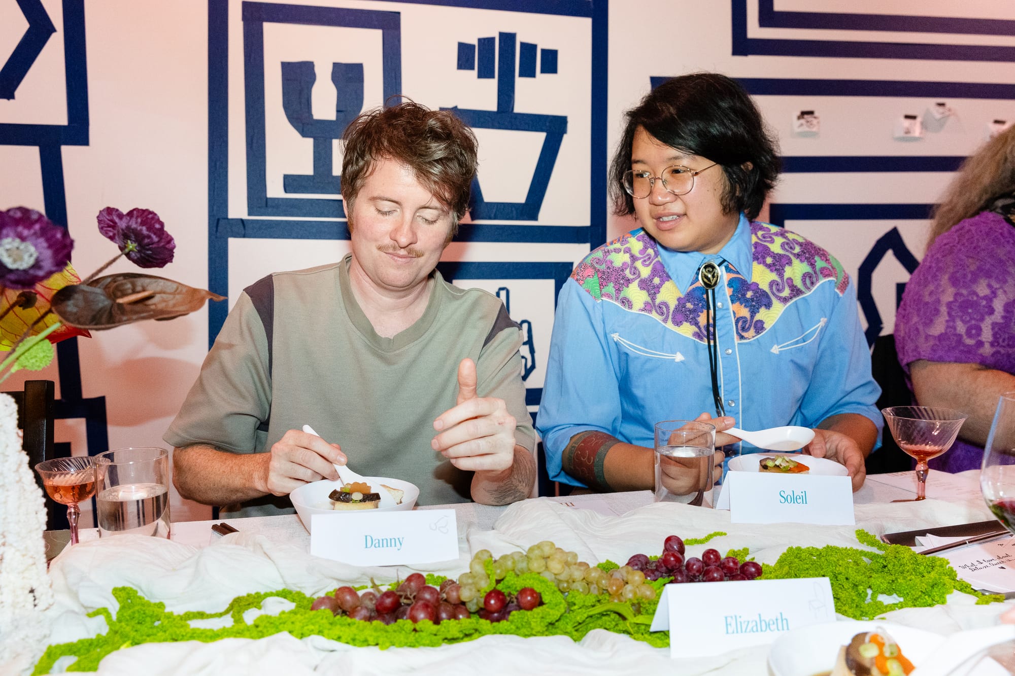 Danny and Soleil look cute and eat food at a nicely set dinner table. 