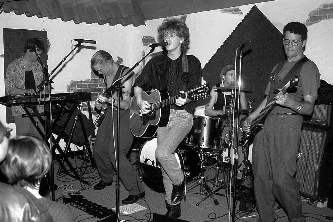 a black and white photo of a band playing a small club