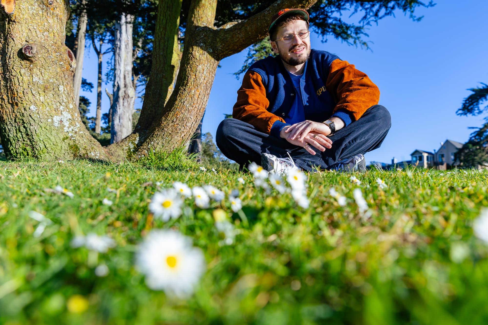 A rapper sits in a field of flowers in San Francisco.
