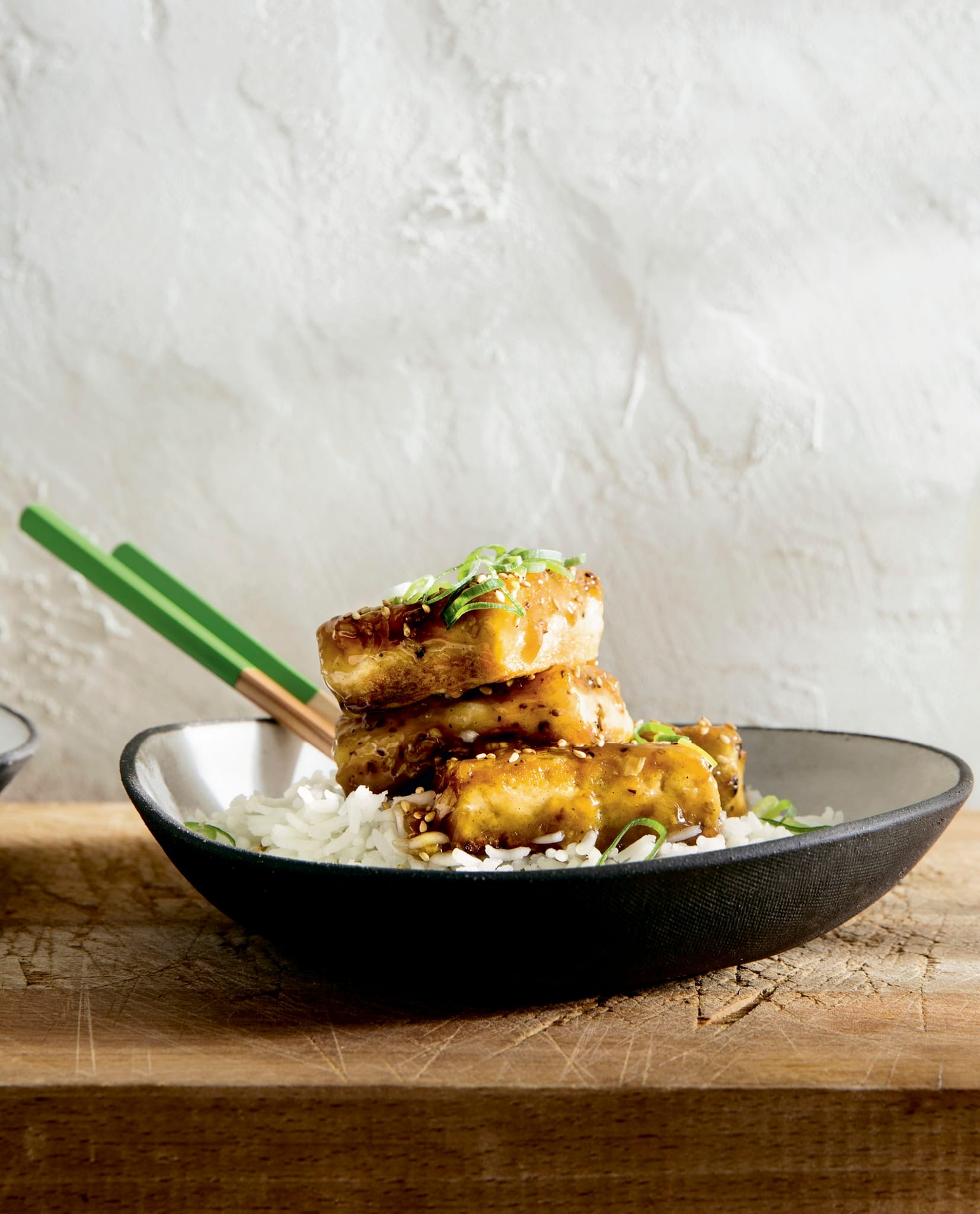 A stack of seared tofu on white rice.