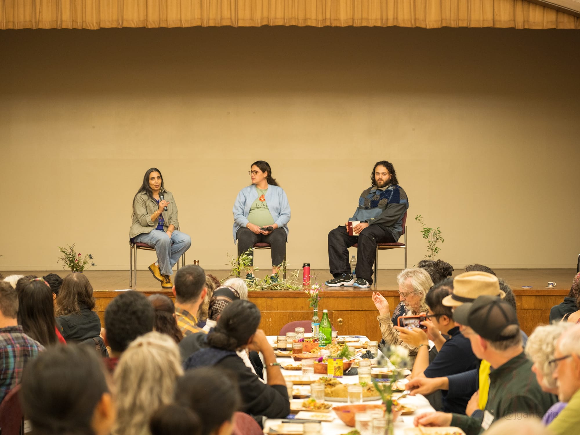Three people seated on stage answering questions from the diners.