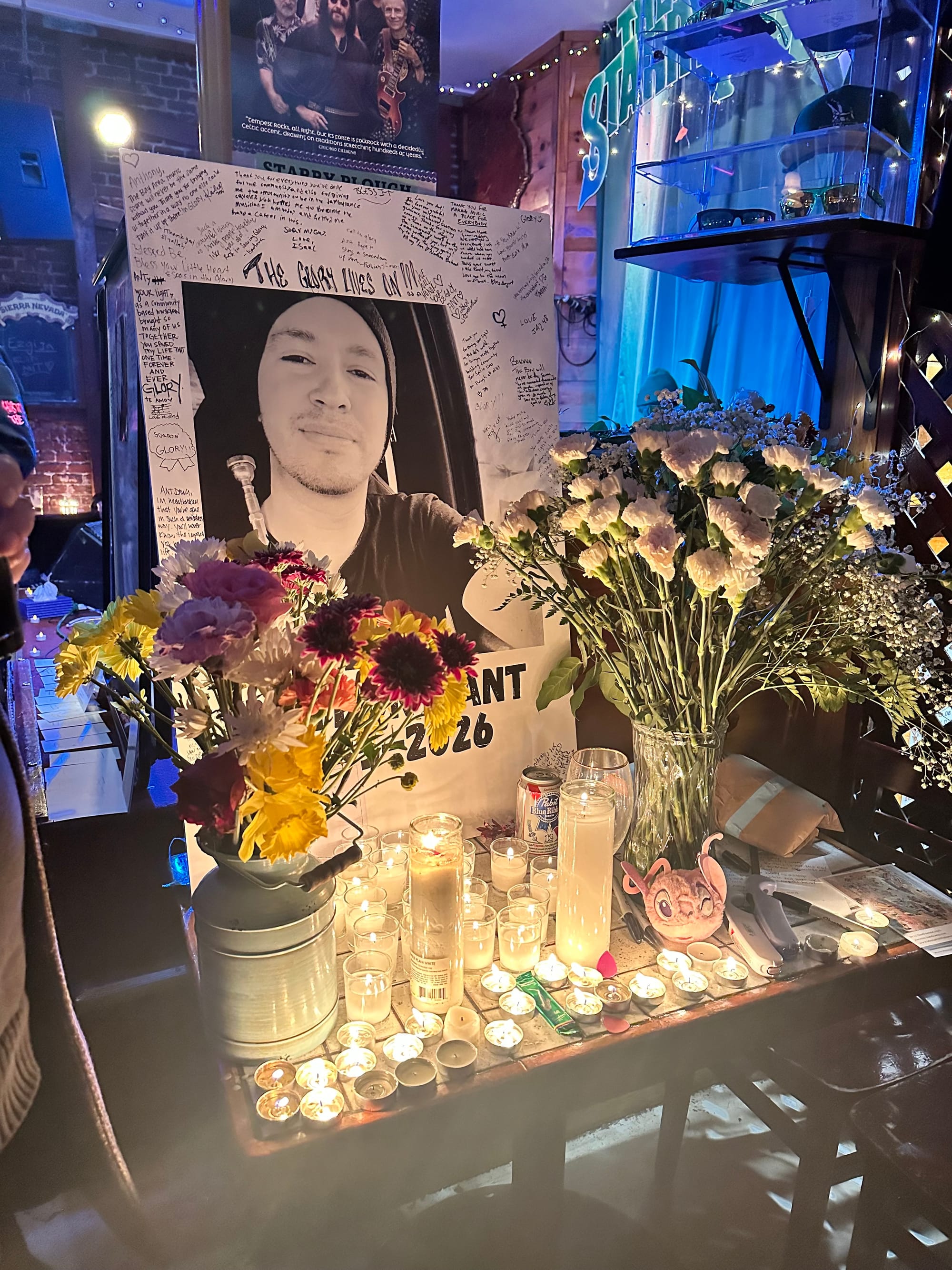an altar with candles and a black and white photo of a young man in a beanie