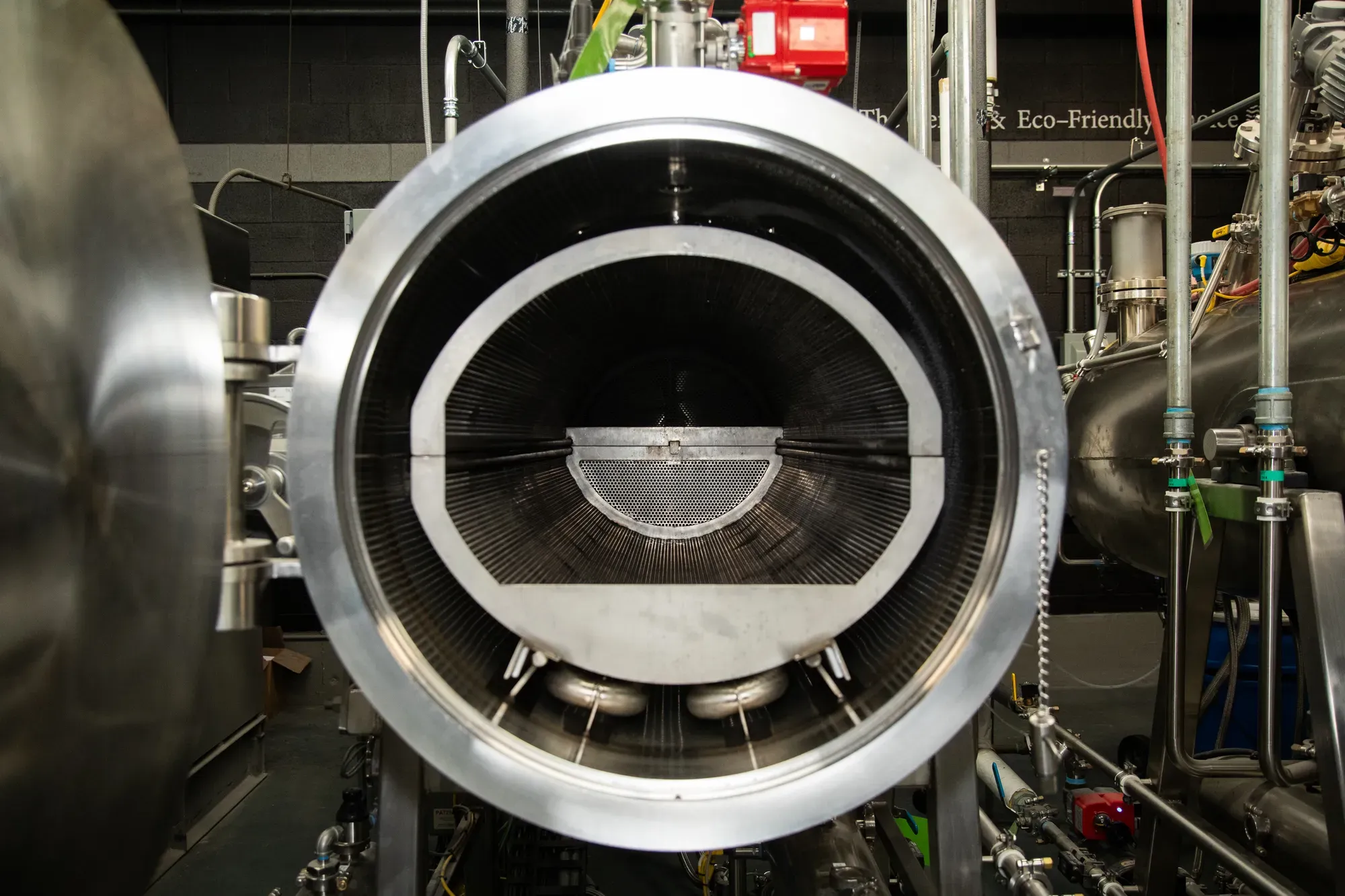 A tube-like aquamation machine is seen head on with the door open