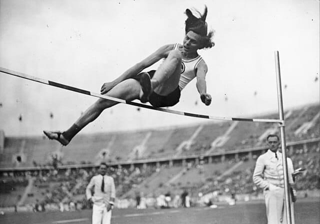 A black and white photograph of a person high jumping at the 1936 Olympics.