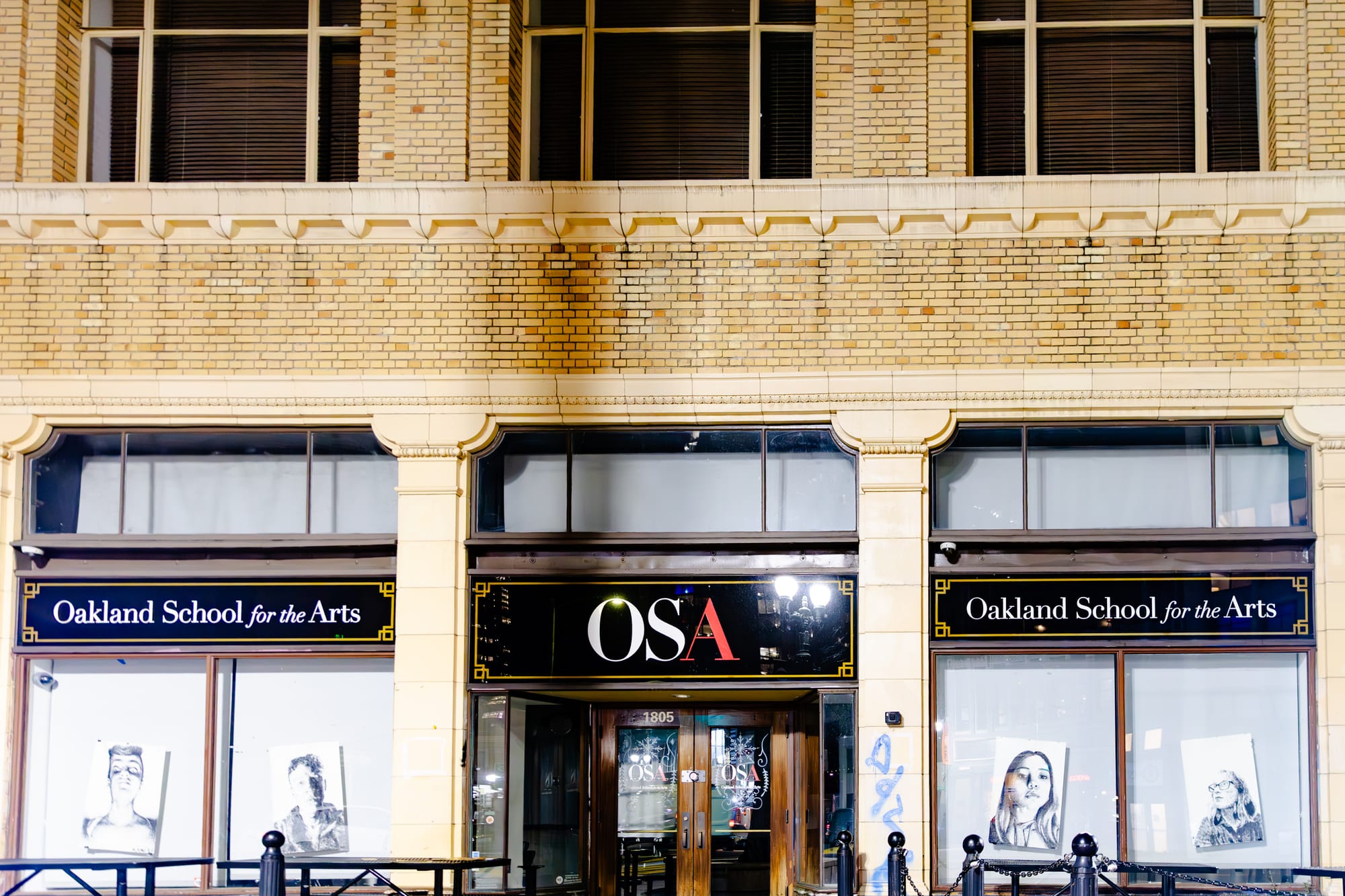 Oakland School of the Arts is in an old brick building, with black and white images of students in its windows