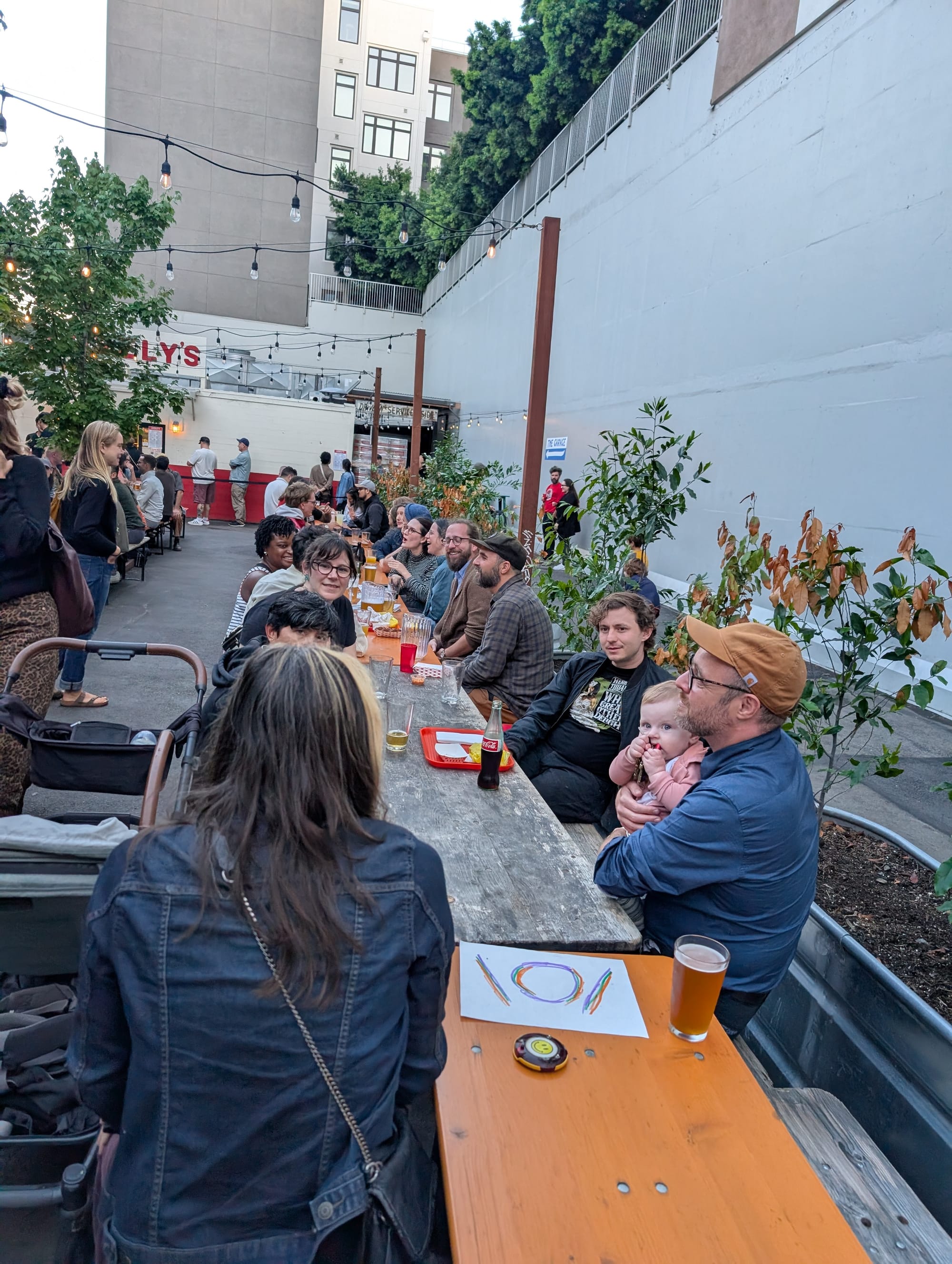 a long table of people at a crowded beer garden