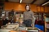 A young woman in jeans and a leopard print sweater looks through records in a school library